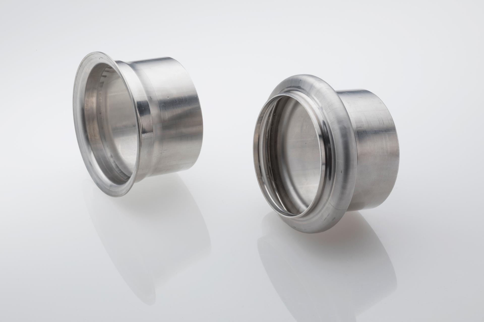 Zwei zylindrische Edelstahl-Flanschhülsen für Rohrverbindungen.