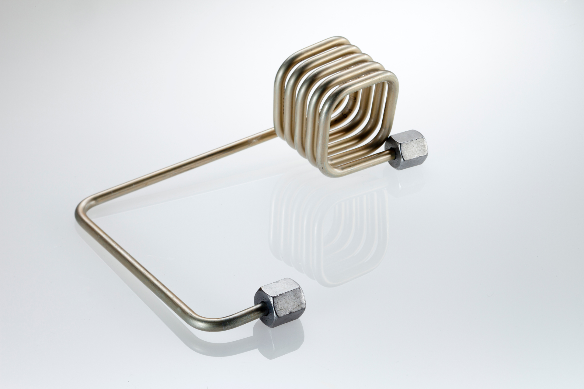 Spiralig gebogenes Metallrohr mit Anschlüssen für Wärmetauscher in HVAC-Systemen.