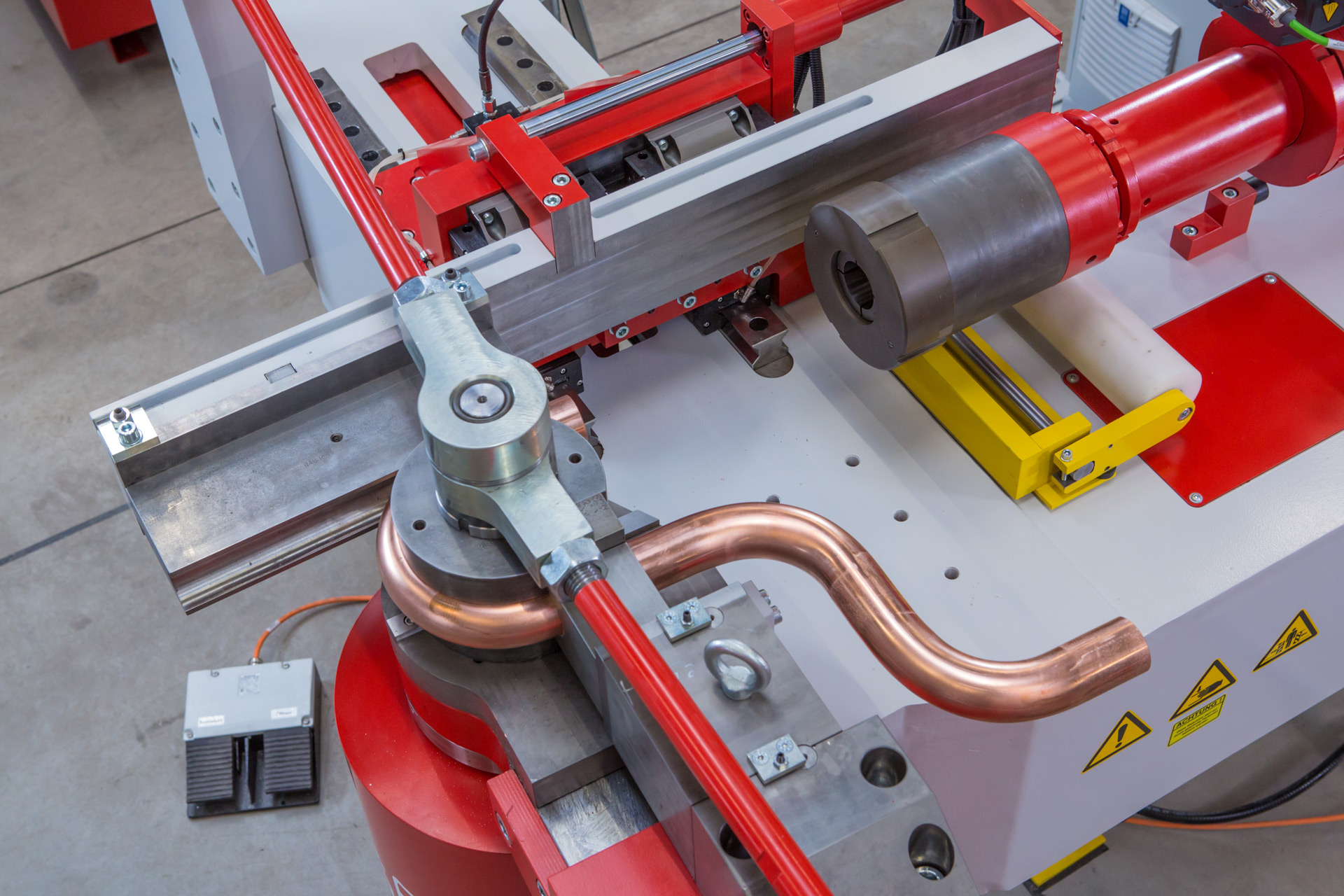 CNC-Rohrbiegemaschine t bend POWERLINE 90 mit Biegekopf beim Formen eines Kupferrohrs.