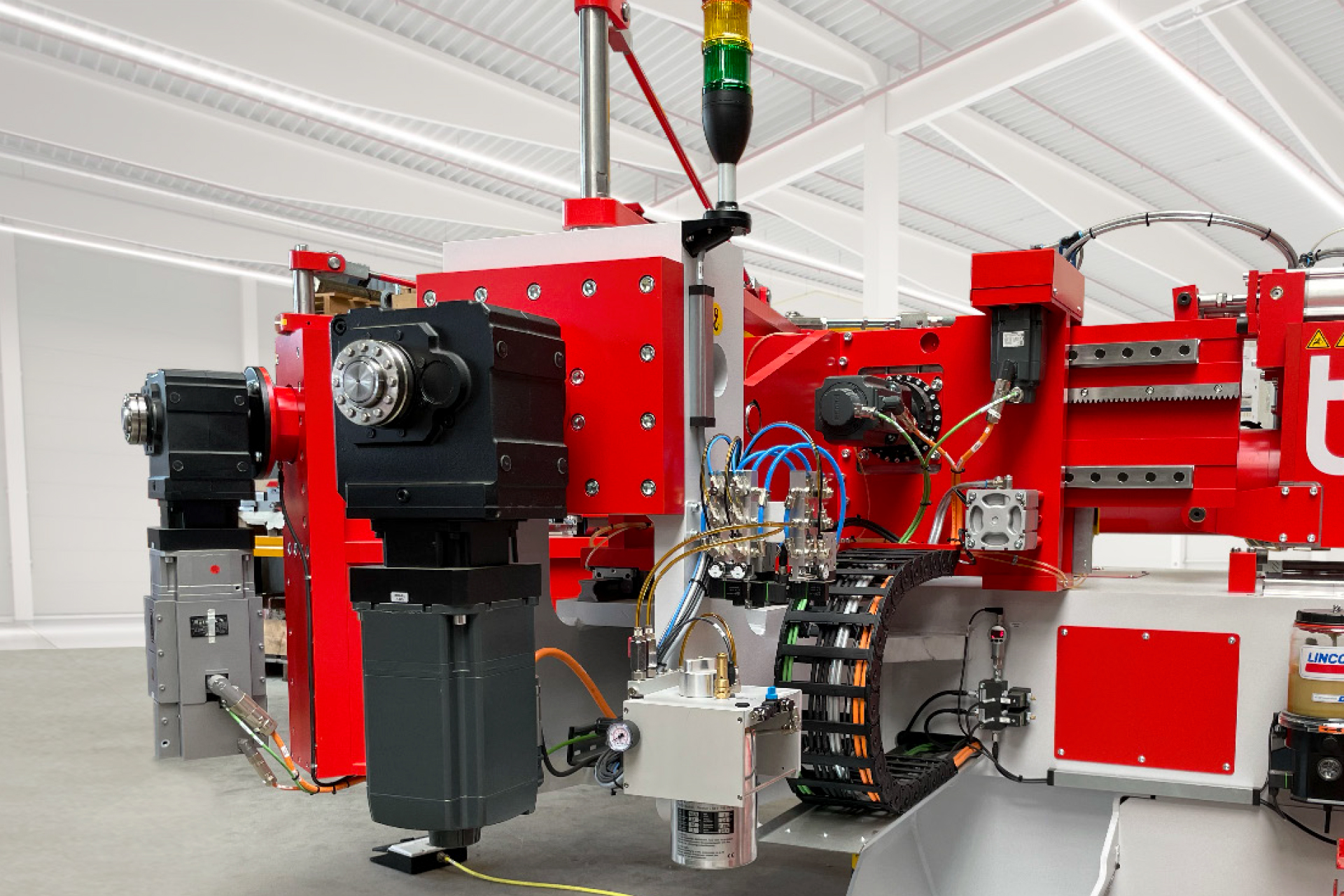 Detailaufnahme einer voll elektrischen CNC-Rohrbiegemaschine Typ t bend PROLINE von transfluid mit Antriebseinheiten und Steuerkomponenten.